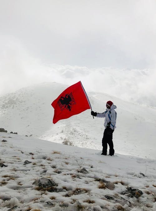 free-photo-of-man-with-flag-of-albania-in-mountains